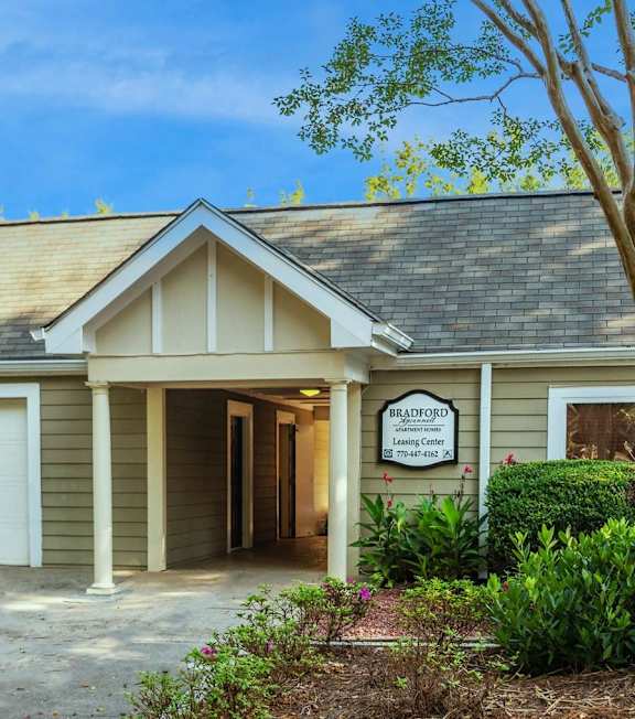A building with a driveway and trees in front of it at Bradford Gwinnett Apartments and Townhomes in GA, 30071