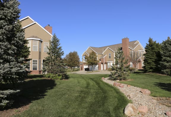Large green space with pine trees surrounding villas