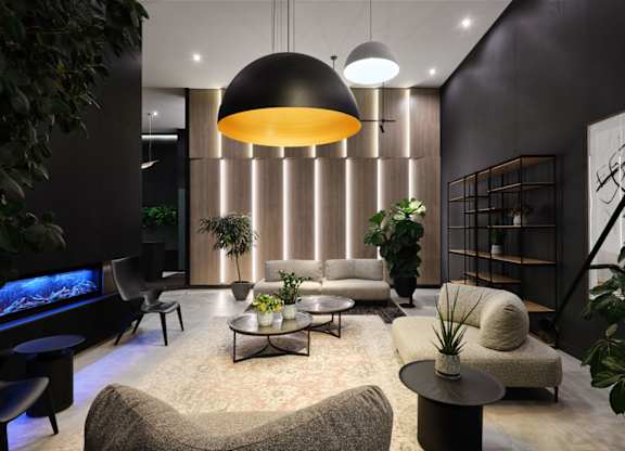 Contemporary living room with pendant lighting and plants at Baseline Apartments, Ottawa, ON