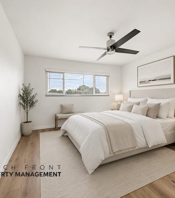 A well-lit bedroom with a large bed and a ceiling fan.