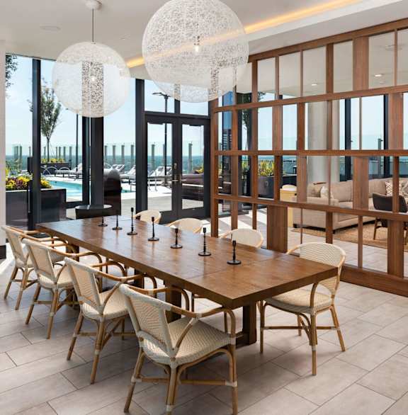 A modern dining room with a long wooden table and chairs at 903 Peachtree in Atlanta, GA 30309