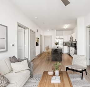 A modern living room with a white couch and a wooden coffee table.