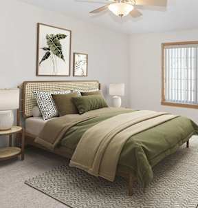 A bedroom with a bed, a ceiling fan, and a window.
