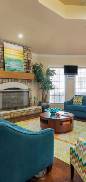 A living room with a blue couch and a yellow and red chair.