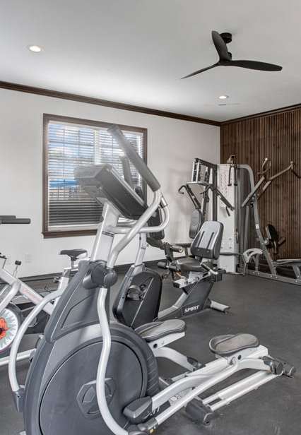 A gym with a variety of exercise equipment including treadmills, stationary bikes, and weight machines.