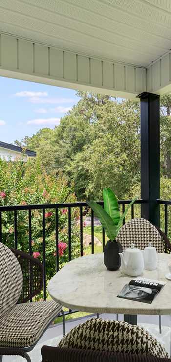 A patio with a table and chairs overlooking a garden. at Dothan Farms, Dothan, AL, 36305
