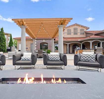 A patio with a fire pit and couches.