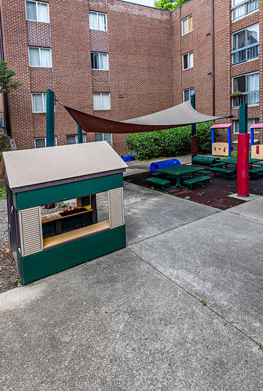 a play area with a hot dog cart in front of an apartment building