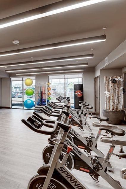 a gym with a bunch of bikes and a tv