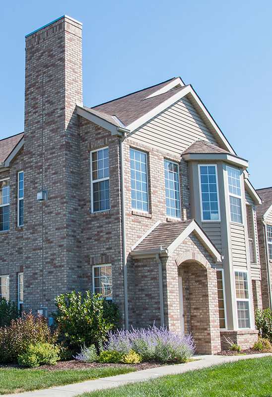 a villa building with brick and stone exterior on a sunny day
