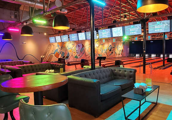 A bowling alley with a bar and seating area.