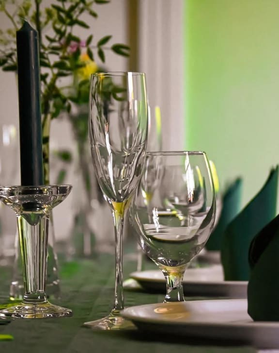 A beautifully set table with wine glasses, plates, and napkins, perfect for a gathering or special occasion.