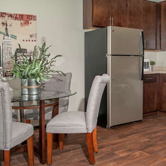A kitchen with wooden floors and a refrigerator.