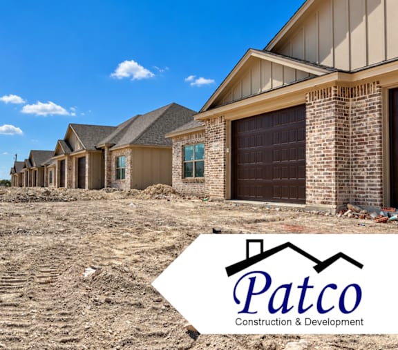 A construction site with a house under construction and a logo of Patco Construction & Development.