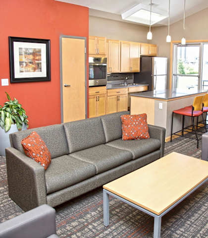 a living room with a couch and a table and a kitchen