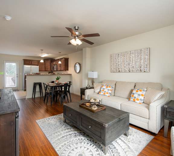 A living room with a couch, coffee table, and a ceiling fan.