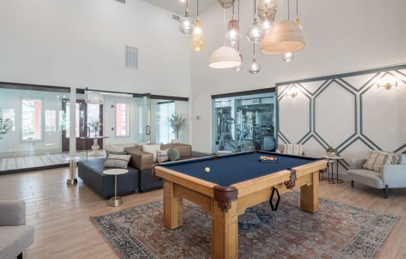 a large living room with a pool table and couches
