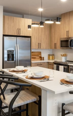a kitchen with a large island with chairs and a table