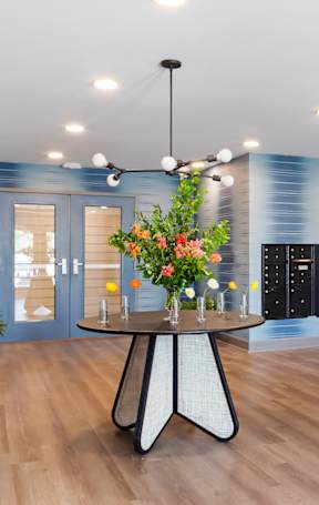 A room with a round table and a flower arrangement on it.