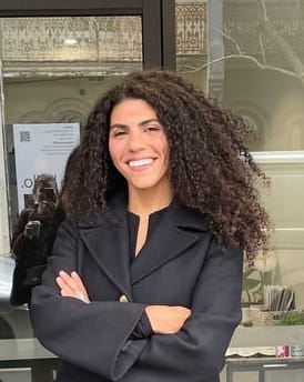 a woman standing in front of a door with her arms crossed
