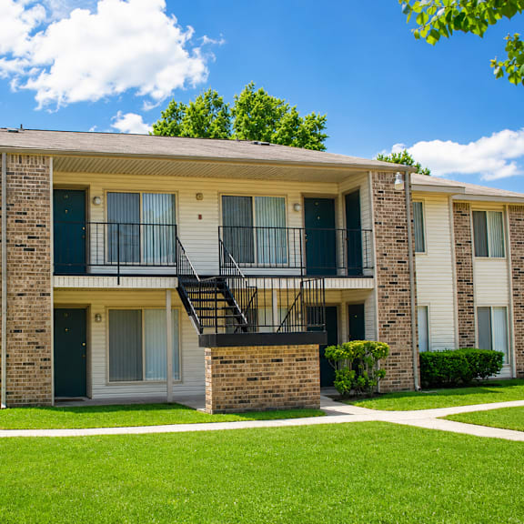 A sign for Fawn Ridge Apartments is shown in front of a green lawn.