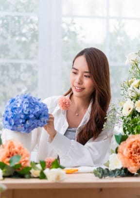 a woman arranging flowers in a flower shop  at Lexington on the Green, Raleigh, NC