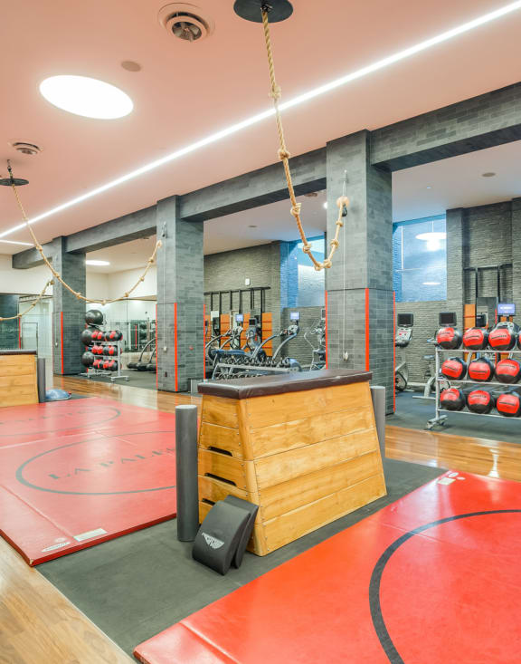 a large fitness room with a basketball court and weights