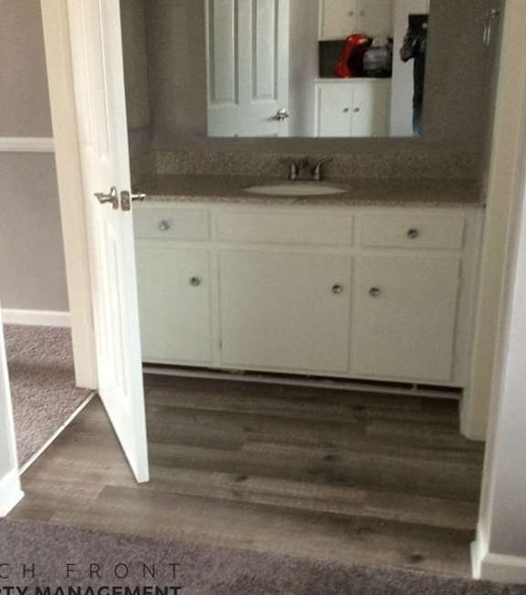A bathroom with a sink, mirror, and cabinets.