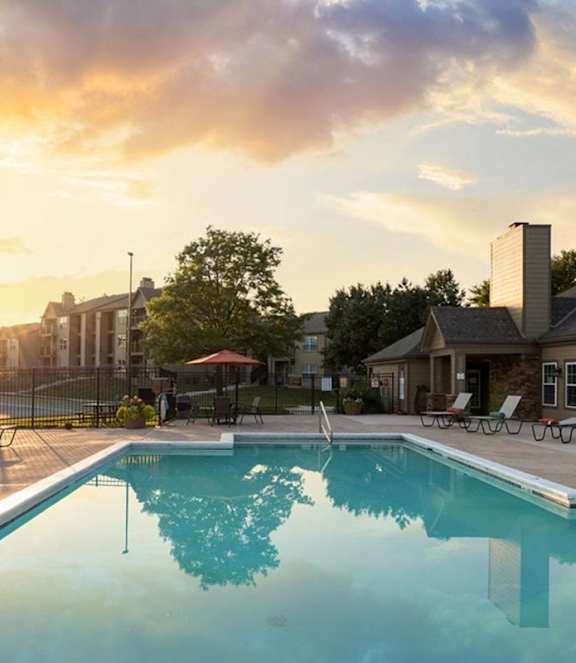 Swimming pool at The Lakes Apartments at sunset with warm evening light reflecting on the water.