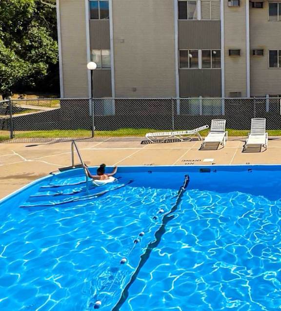 A large blue swimming pool in front of a building at The Ridges Apartments, Des Moines, IA 50315