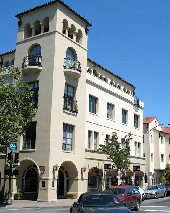 A street view of a building with a car parked in front.