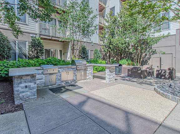 A stone wall with a bench in front of a building.