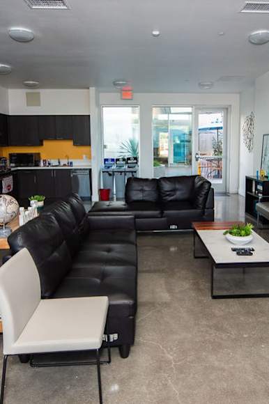 A living room with a black couch and a white chair.