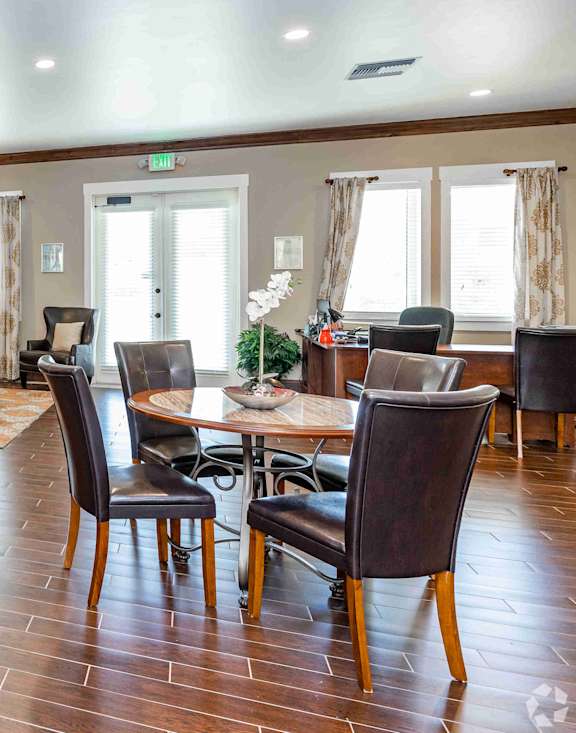 A living room with a wooden floor and a large painting on the wall.