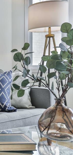 a living room with a gray couch and blue and white pillows