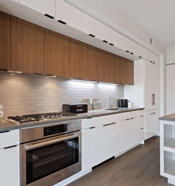 a kitchen with wooden cabinets and stainless steel appliances at Tribeca NOMA apartments