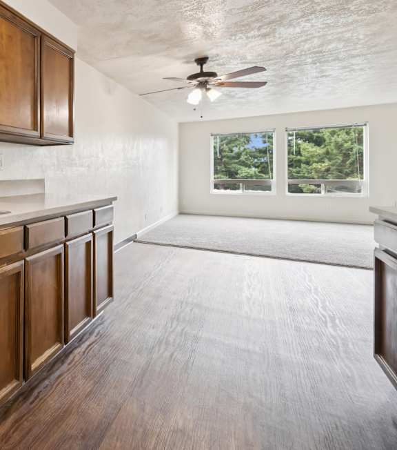 A kitchen with a white stove top oven and wooden cabinets.