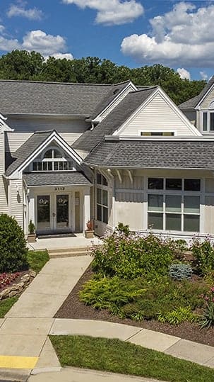a large white house with a garden in front of it
