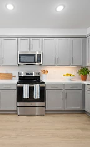 A kitchen with white cabinets and appliances.