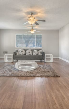 a living room with a fireplace and a ceiling fan at Ocean Villas, Oxnard