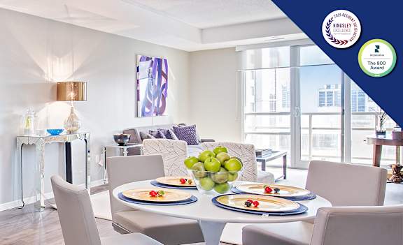 A modern kitchen with a dining table set for two.