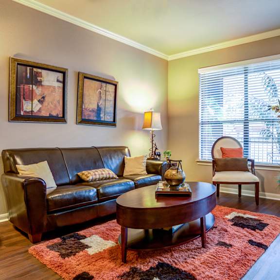 an open concept living room and dining area with a white dining table and rattan chairs