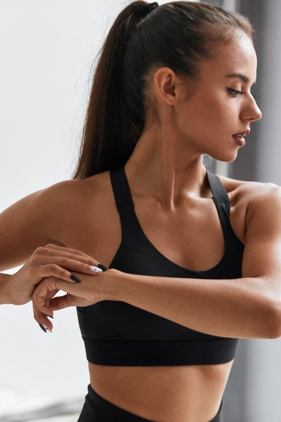 a woman standing in a gym with her arms crossed
