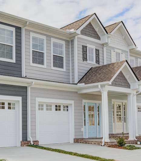 A row of houses with white garage doors.