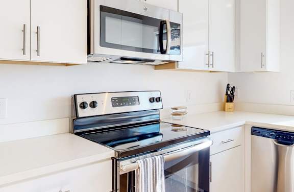 A modern kitchen with a stainless steel stove, oven, and microwave.