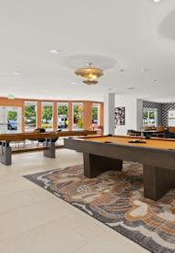 A kitchen with white cabinets and a white island with stools.