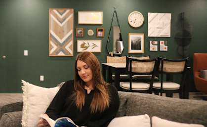 a woman sitting on a couch reading a book in a living room  at Timber Ridge, Forest Lake, 55025