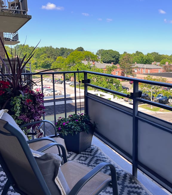 a balcony with a view of a parking lot and trees
