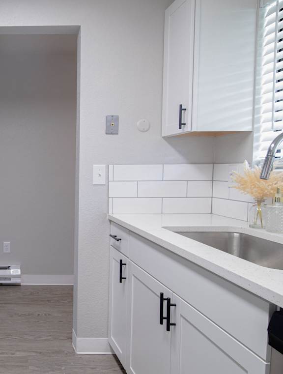 A kitchen with white cabinets and a black stove top oven.