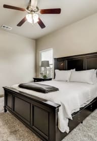 a bedroom with a bed and a ceiling fan cypress creek apartments